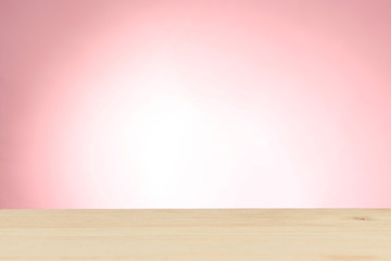 Wooden table on light pink background