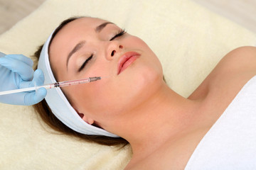 Obraz na płótnie Canvas Young woman receiving plastic surgery injection