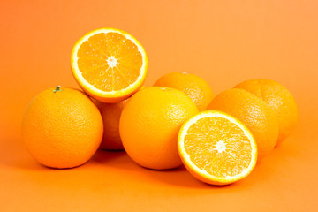 Juicy oranges in front of orange background