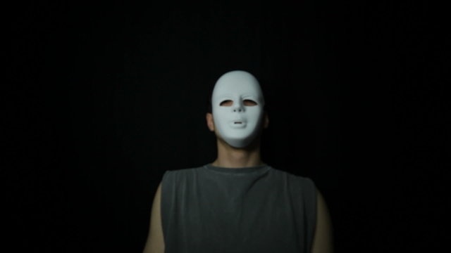 Scary masked man over dark background