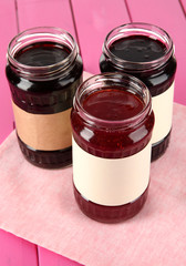 Tasty jam in banks on table