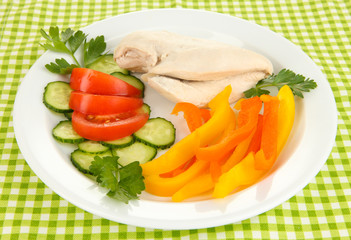 Boiled chicken breast on plate with vegetables close up
