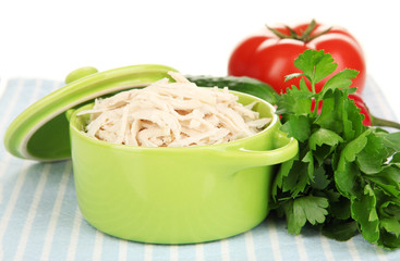 Shredded boiled chicken in green pan close up