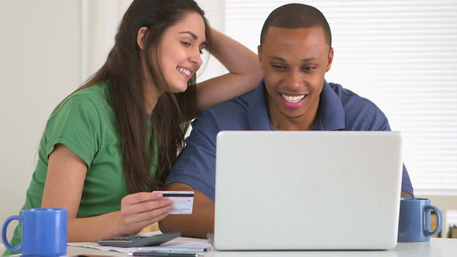 African american and caucasian couple paying bills together