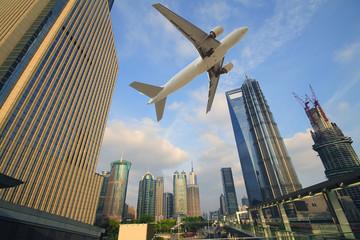 Aircraft flying over the modern city buildings over