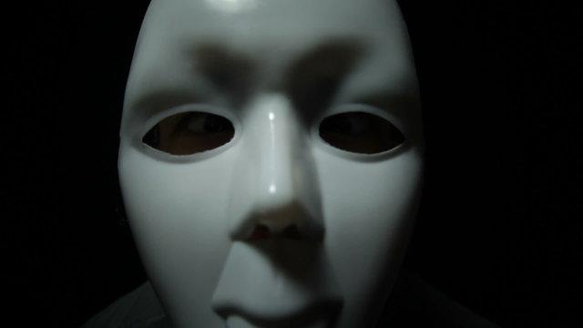 Scary masked man over black background