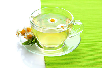 Cup of herbal tea with wild camomiles and mint, isolated