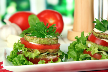 Tasty roasted marrow and tomato slices with salad leaves,
