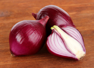 Purple onion on wooden background