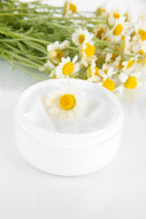 Fototapeta na wymiar Cream with chamomile isolated on white