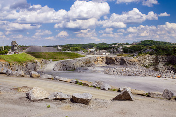 Working rock quarry under cloudy blue sky