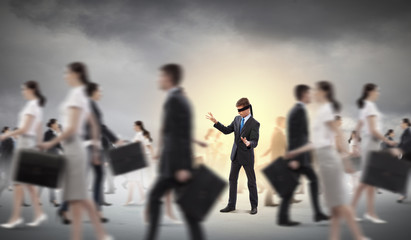 Businessman in blindfold among group of people