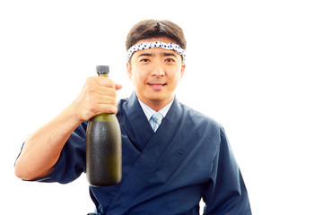日本酒の瓶を持つ笑顔の寿司職人