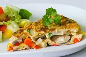 Vegetable omelet with salad on the background