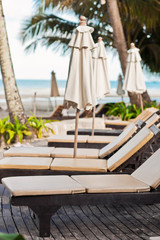 Beach chairs near swimming pool in tropical resort, Thailand.