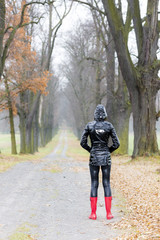 Fototapeta premium woman wearing rubber boots in autumnal alley