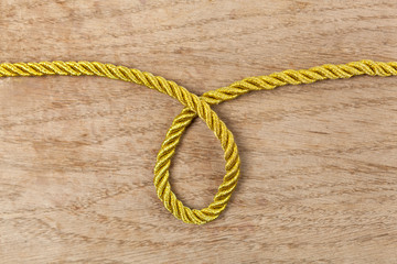 Golden rope loop on wooden background