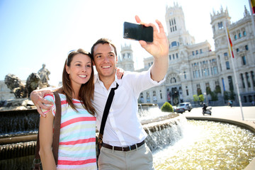 Couple taking pictures in Plaza de Cibeles, Madrid
