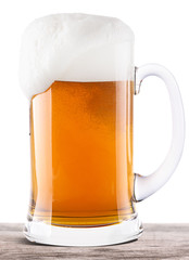 Frosty glass of light beer on a wooden table