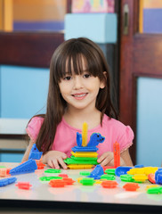 Little Girl With Construction Blocks In Classroom