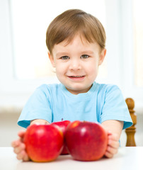 Fototapeta na wymiar Portrait of a happy little boy with apples