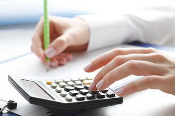 Financial data analyzing. Counting on calculator.