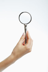 Hand holding a magnifying glass