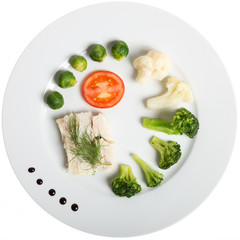 White plate with healthy food: fish and vegetables