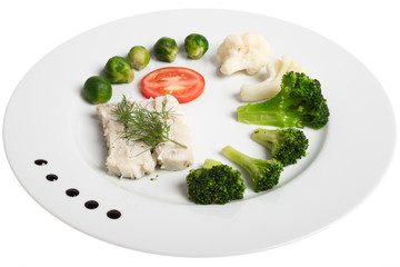 White plate with healthy food: fish and vegetables