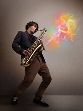 Attractive musician playing on saxophone with colorful abstract
