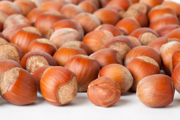 Unbroken hazelnuts on white surface
