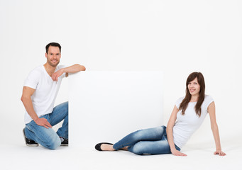 junge Leute präsentieren große Werbetafel