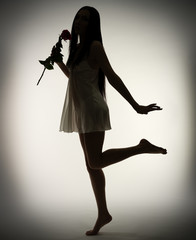 Silhouette of young girl with rose flower