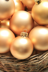 Golden Christmas ornaments in a wicker basket