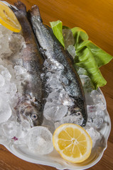 Raw fish on the plate and light background