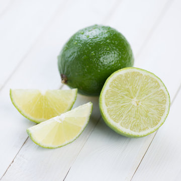 Fresh ripe lime and its segments on wooden boards, close-up
