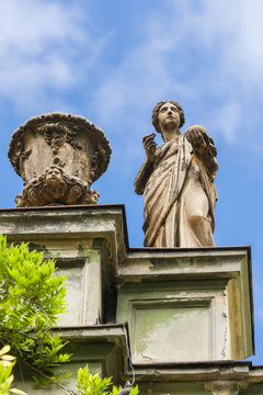 Antique female statue on the roof of an old building