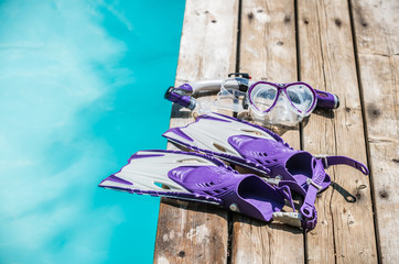 Diving goggles, snorkel and fins on the jetty