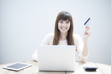 Portrait of beautiful, young woman using a laptop while holding 