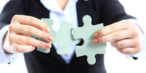 Business woman showing two jigsaw puzzle pieces