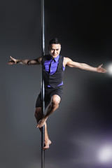 Pole dance man over black background with flashes