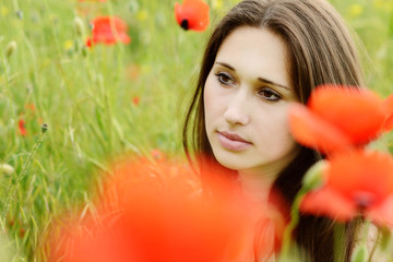 Naklejka premium pensive girl in poppies field