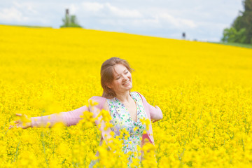 Fototapeta premium lachende frau im raps feld