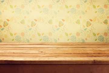 Empty wooden deck table over floral print wallpaper