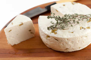 caciotta nostrana con olive ed origano su una tavola di legno