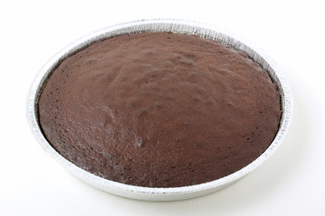 torta al cacao in contenitore di alluminio sfondo bianco