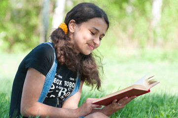 Teen girl reading a book on nature