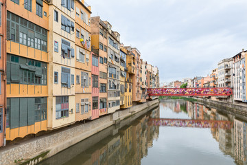View of Girona with colorful houses reflected in water, Spain