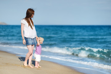 Mother and daughter walking along a beach