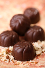 Chocolate candies with nuts, on color background